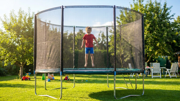 Jeune garçon souriant qui saute joyeusement sur un trampoline de jardin équipé d'un filet de sécurité protecteur.