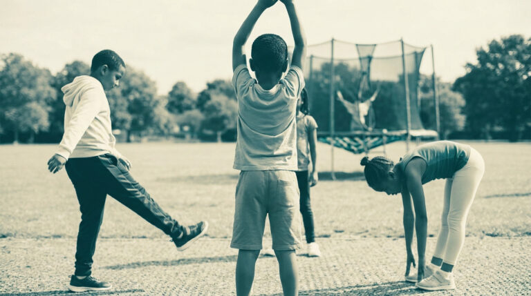 Enfants faisant des exercices d'étirement et d'échauffement dans un parc avant de faire du trampoline.