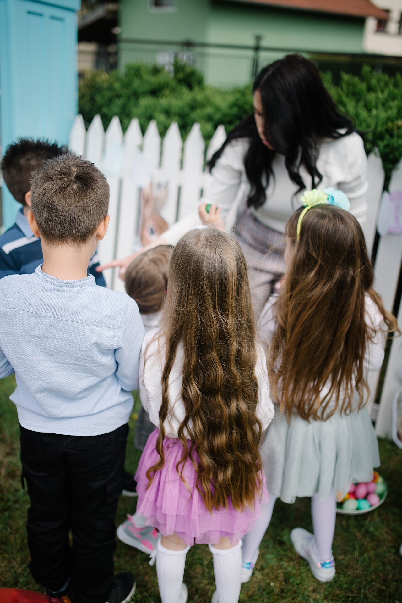 Parent aidant deux enfants à jouer ensemble dans un jardin sans compétition